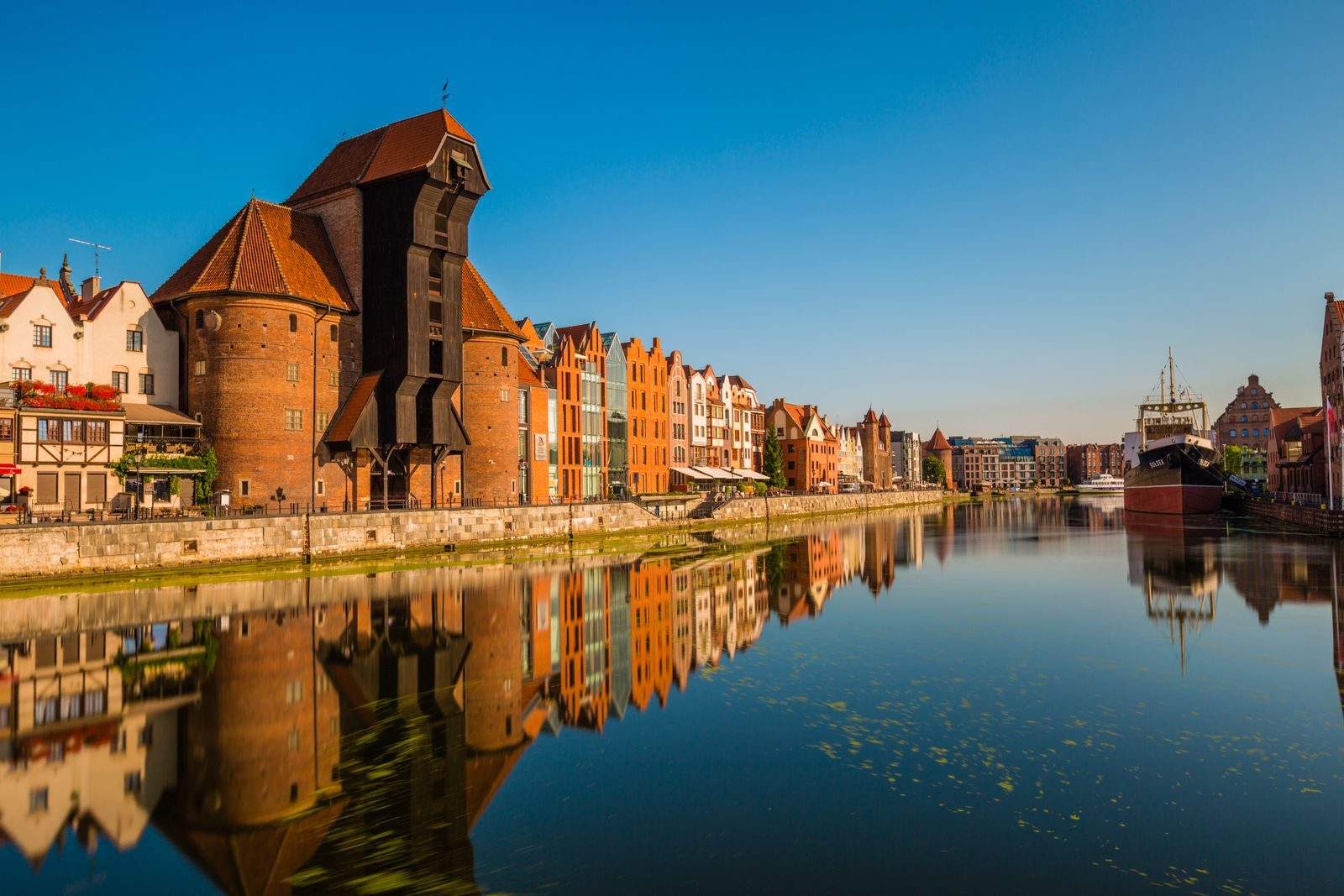 Historic waterfront buildings reflected in the Motława River in Gdańsk